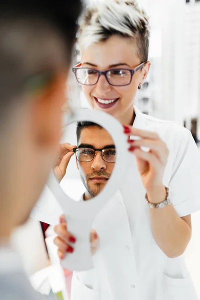 Jovem Optometrista Ajuda Cliente Escolher Óculos Certos — Fotografia de Stock