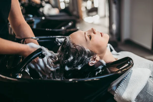美しい若い女性は髪を洗う取得します ヘアサロンスタイリングのコンセプト — ストック写真