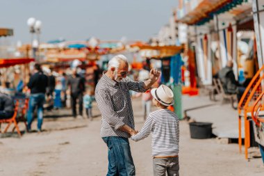 Büyükbaba ve torunu eğlenmek ve eğlence parkında birlikte iyi kaliteli zaman harcamak.