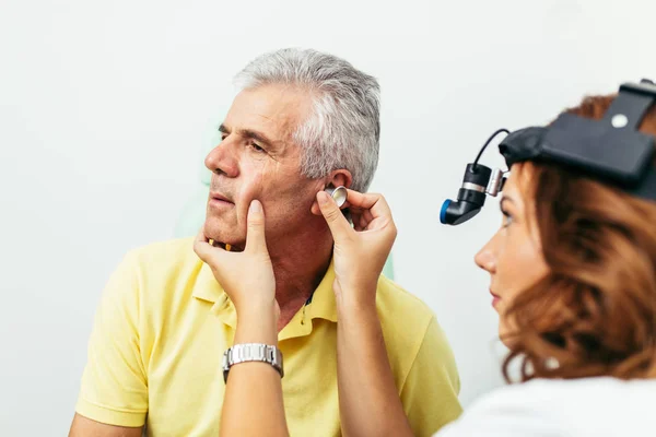 Senior man at medical examination or checkup in otolaryngologist's office