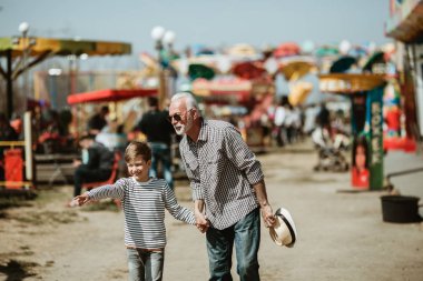 Büyükbaba ve torunu eğlenmek ve eğlence parkında birlikte iyi kaliteli zaman harcamak.