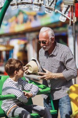 Büyükbaba ve torunu eğlenmek ve eğlence parkında birlikte iyi kaliteli zaman harcamak.