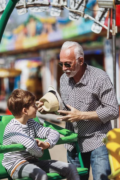 Büyükbaba ve torunu eğlenmek ve eğlence parkında birlikte iyi kaliteli zaman harcamak.