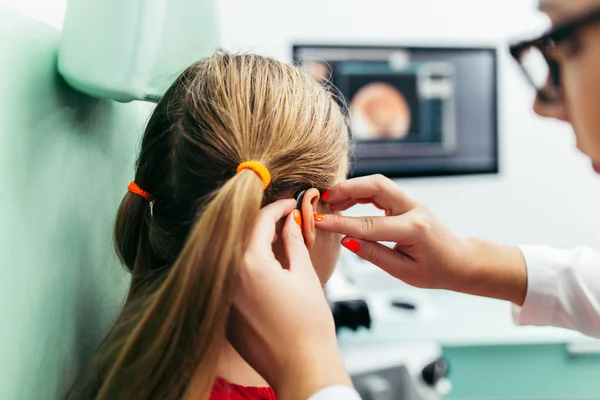 Young girl at medical examination or hearing aid checkup in otolaryngologist's office