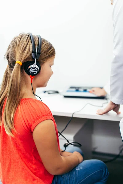 Young girl at medical examination or hearing aid checkup in otolaryngologist\'s office