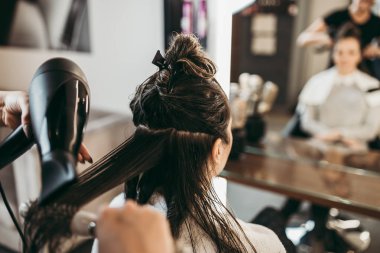 Güzeller güzeli esmer kadın, kuaförde uzun saçlı, saçları uçuyor. Kuaför kuaförü tasarımı.