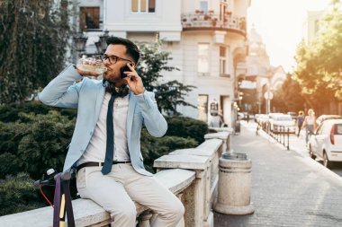 Şehir caddesinde elektrikli scooter kullanan ve kullanan genç modern bir adam. Modern ve ekolojik ulaşım kavramı.