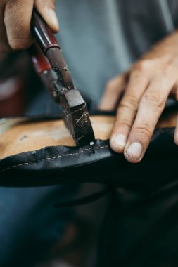 Eski ayakkabıcı çekimi yakın deri kenarları kesme. Ayakkabı yapma sürecinin geleneksel yolu.