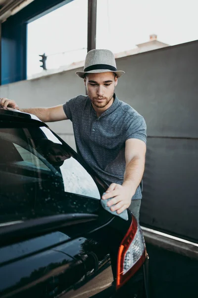 Mladý Pohledný Muž Kloboukem Čištění Auto Hadrem Auto Detailní Nebo — Stock fotografie