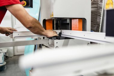 Elle çalışan işçi PVC kapı ve pencereleri birleştiriyor. İmalat işleri. Seçici odaklanma. Alüminyum ve PVC pencere ve kapı üretim fabrikası.