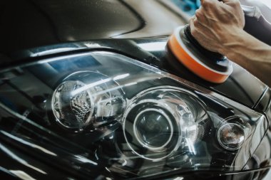 Araba tamiri, oto tamirhanesinde orbital parlatıcıyla el işi. Seçici odak.