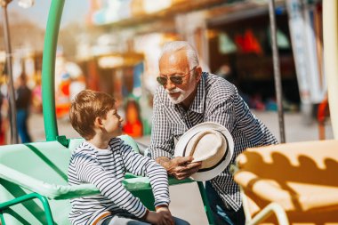 Büyükbaba ve torunu eğlenmek ve eğlence parkında birlikte iyi kaliteli zaman harcamak.