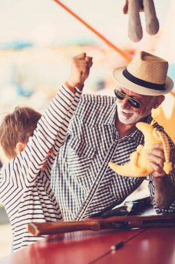 Büyükbaba ve torunu eğlenmek ve eğlence parkında birlikte iyi kaliteli zaman harcamak. Büyükbaba ödülü kazanmak için yardım ederken çocuk hava tabancası ile çekim. 