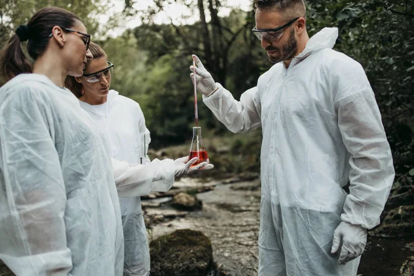 Tudósok Biológusok Kutatók Védőruhában Szennyezett Folyóból Vesznek Vízmintákat — Stock Fotó