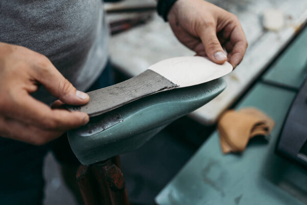 Крупный план старого сапожника в его магазине. Традиционный способ производства обуви
.