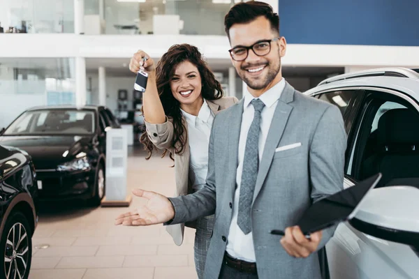 快乐和美丽的中年商务女性在展厅购买新车 一个善良的卖家帮助她做出正确的决定 — 图库照片