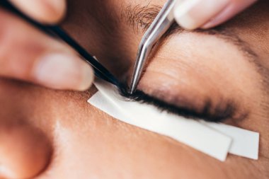 Kirpik uzatma işleminde güzel orta yaş kadın. Kozmetik ve vücut bakımı yakın çekim.