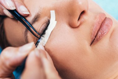 Kirpik uzatma işleminde güzel orta yaş kadın. Kozmetik ve vücut bakımı yakın çekim.