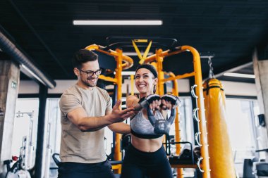 Modern fitness spor salonunda Kettlebell ile alıştırma egzersiz genç fit ve çekici adam ve kadın.