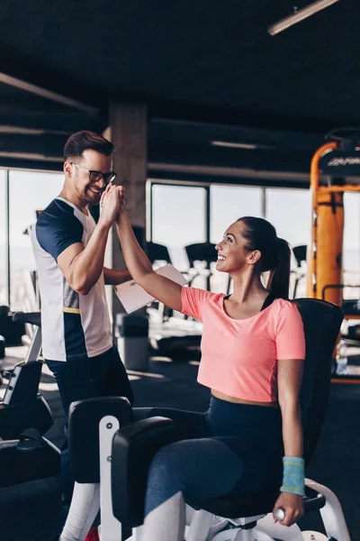 Młoda Atrakcyjna Kobieta Ćwicząca Nowoczesnej Siłowni Wraz Osobistym Instruktorem Fitness — Zdjęcie stockowe