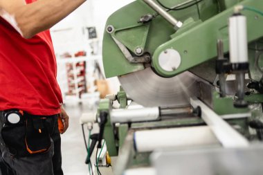 Alüminyum ve PVC profilleri kesen el işi işçisi. İmalat işleri. Seçici odaklanma. Alüminyum ve PVC pencere ve kapı üretim fabrikası.