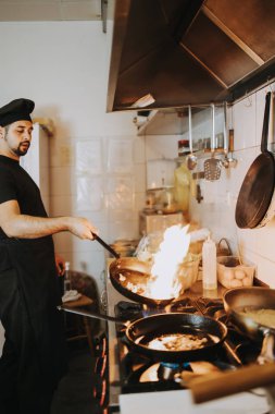 Profesyonel aşçı restoran mutfağında çalışıyor ve lezzetli geleneksel yemekler yapıyor..