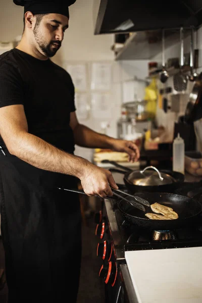 Professional chef working in restaurant kitchen and making delicious traditional food.