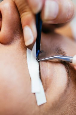 Kirpik uzatma işleminde güzel orta yaş kadın. Kozmetik ve vücut bakımı yakın çekim.