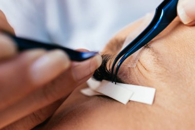 Kirpik uzatma işleminde güzel orta yaş kadın. Kozmetik ve vücut bakımı yakın çekim.