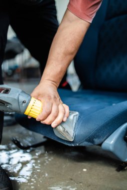 Araba yıkama işçisi, ıslak temizlik aracı, iç mekan ve koltuklar.