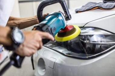 Araba tamiri, oto tamirhanesinde orbital parlatıcıyla el işi. Seçici odak.