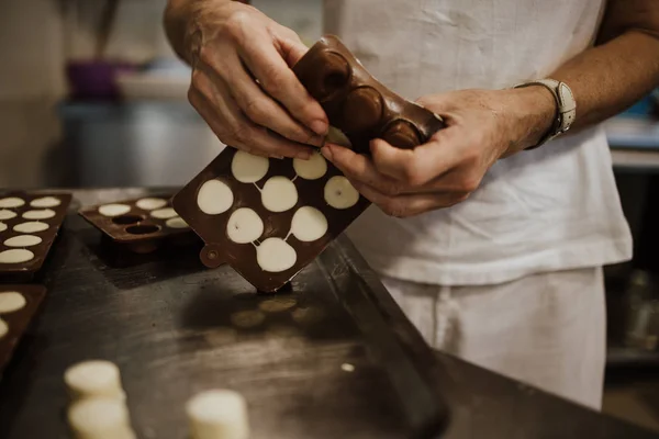 Professional confectioner working making and decorating delicious sweets. Close up shot.