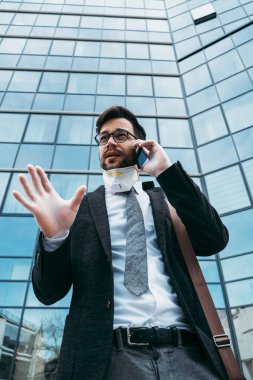 Şehir caddesinde telefon kullanan koruyucu maskeli bir iş adamı. Virüs salgını veya salgın hastalık konsepti.