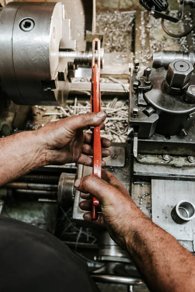 Close up shot of manual worker hands. Factory for industrial production of hydraulic hoses.