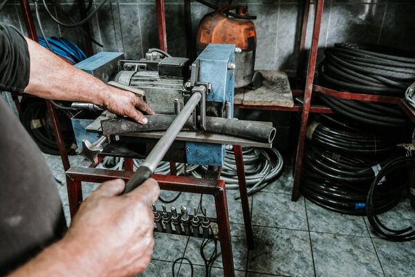 Close up shot of manual worker hands. Factory for industrial production of hydraulic hoses.