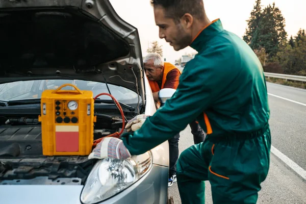 Två Vägassistenter Bogsering Service Försöker Starta Bilen Motor Med Hopp — Stockfoto