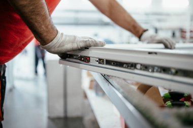 Elle çalışan işçi PVC kapı ve pencereleri birleştiriyor. İmalat işleri. Seçici odaklanma. Alüminyum ve PVC pencere ve kapı üretim fabrikası.