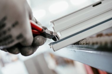 Elle çalışan işçi PVC kapı ve pencereleri birleştiriyor. İmalat işleri. Seçici odaklanma. Alüminyum ve PVC pencere ve kapı üretim fabrikası.