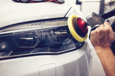 Araba tamiri, oto tamirhanesinde orbital parlatıcıyla el işi. Seçici odak.