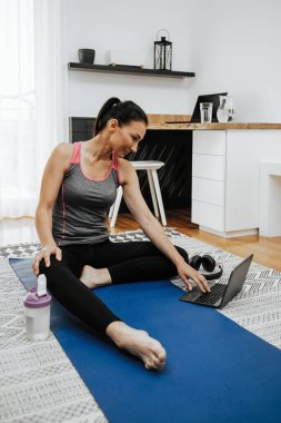 Dairesinde sportif orta yaşlı kadın egzersizi var. Evde kal ve mutlu ol.. 