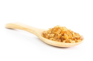 Tahta kaşık beyaz arka planda, sağlıklı kavramı içinde closeup kahverengi şeker kamışı