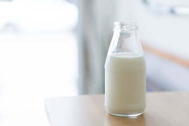 Millk metin için sağlıklı içecek konsepti ve kopya yer için kapıdan gelen ışık üzerinde zemin ahşap masa üzerine şişe portre reklam, seçici ve yumuşak odak 