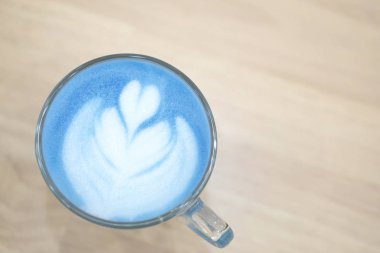 Closeup üstten görünüm bardak latte sanat lale şeklinde ahşap masa, seçici odak üzerinde mavi süt