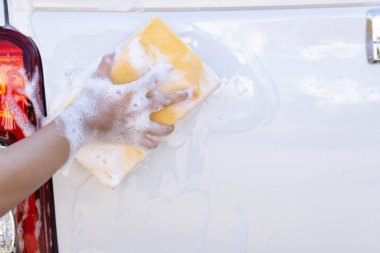 Araba yıkamak için sünger tutan Closeup el