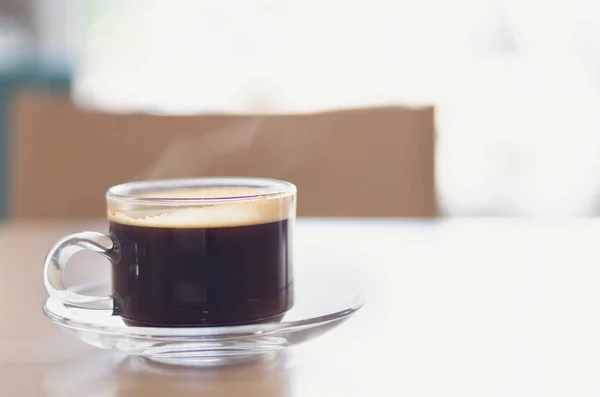Zbliżenie do szklanki gorącej kawy Americano na drewnianym stole z dymem, selektywna ostrość, Vintage Tone — Zdjęcie stockowe