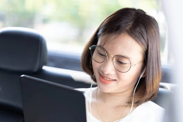Närbild asiatisk kvinna med digital tablett i en bil med glad ansikte — Stockfoto
