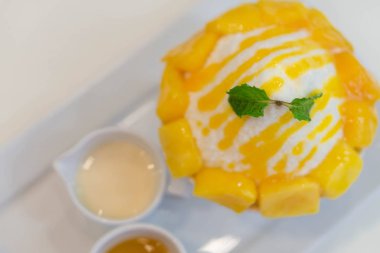 Beyaz tabakta soslu mango bing su 'yu kapat. 