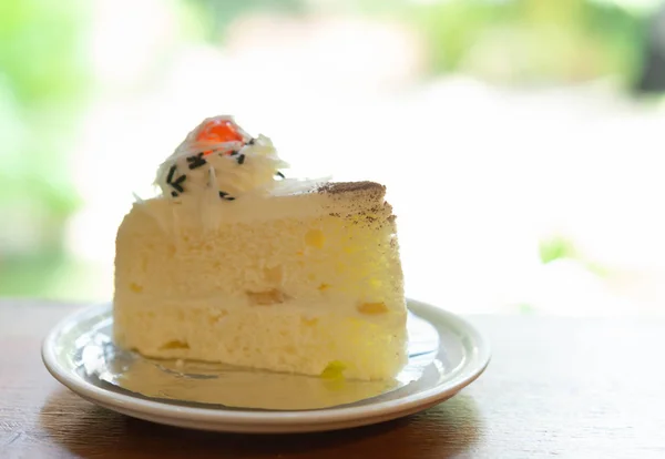 Gâteau au lait en gros plan sur table en bois avec fond naturel vert, mise au point sélective — Photo