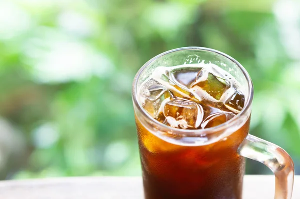 Primer plano vaso de café de hielo americano con fondo verde de la naturaleza, enfoque selectivo — Foto de Stock