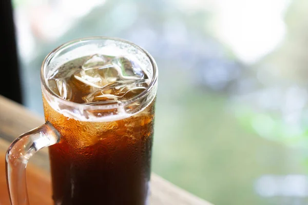 Primer plano vaso de café de hielo americano con fondo verde de la naturaleza, enfoque selectivo — Foto de Stock